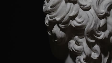 epic studio close up detail shot. rotating antinous gypsum head with moving and changing  lighting. the play of light and shadow on half face of statue of man. on black background isolated 4k