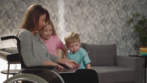 una madre amorosa enseña a los niños curiosos a usar una computadora portátil moderna