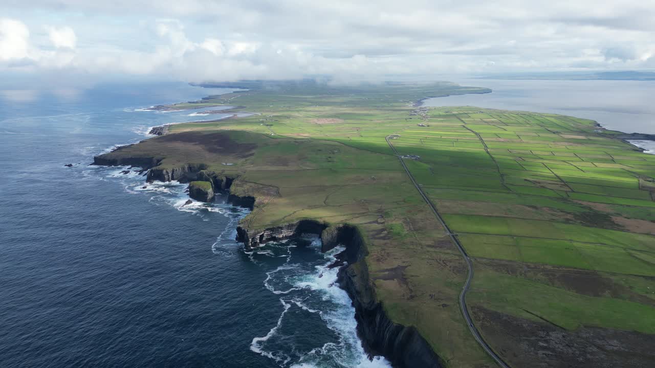 península de loophead con espectaculares acantilados, campos verdes exuberantes y carreteras costeras bajo un cielo nublado, vista aérea