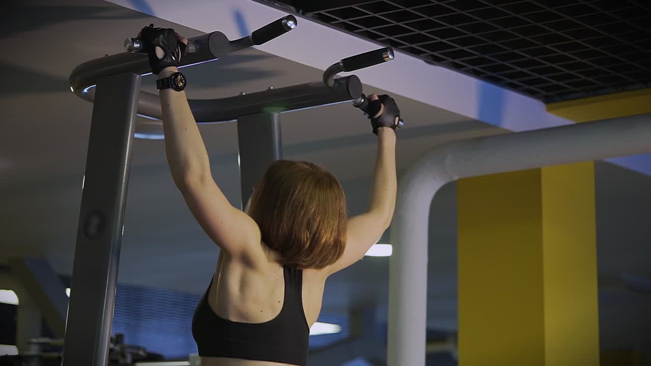 Woman Doing Pull-Ups in a Gym
