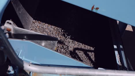 close-up of machinery sorting and stirring small granite stones