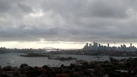 Vista-Nublada-Del-Horizonte-De-Una-Ciudad-Metropolitana-Con-Un-Puente-Y-Una-Torre-Icónicos:-Una-Mezcla-De-Arquitectura-Urbana-Y-Clima-Sombrío