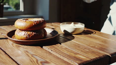 preparing a bagel with butter