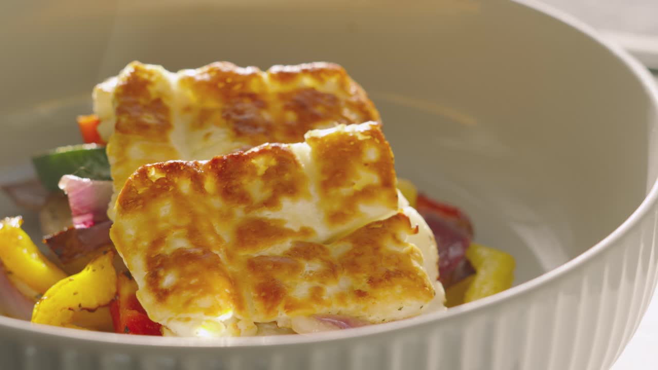 Freshly Grilled Halloumi Slices Resting on Roasted Mediterranean Vegetables Including Peppers, Courgette, Onions. Healthy Eating Summer Fresh Highly Nutritous Lunch.