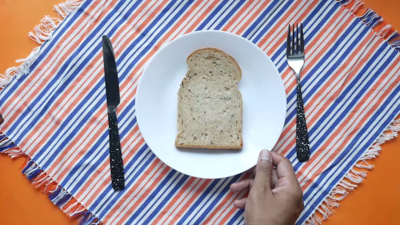 A Slice of Bread on a Plate with a Knife and Fork