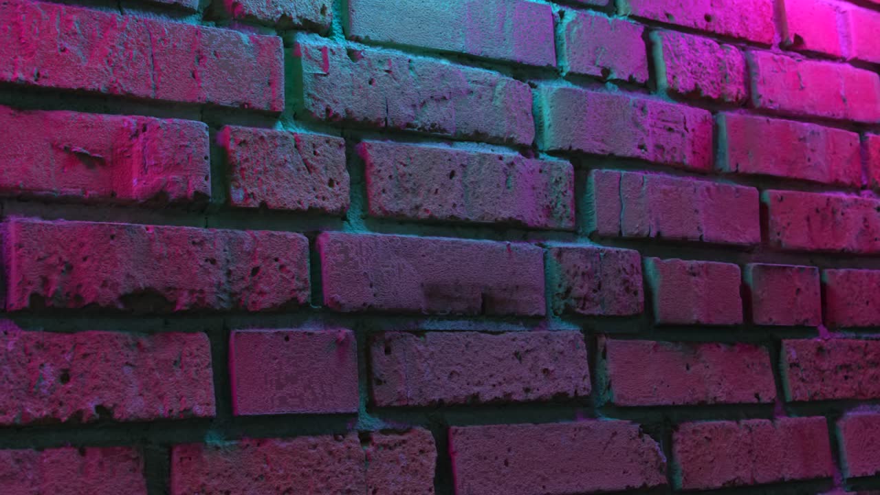 pared de ladrillo iluminada con neón rosa y azul