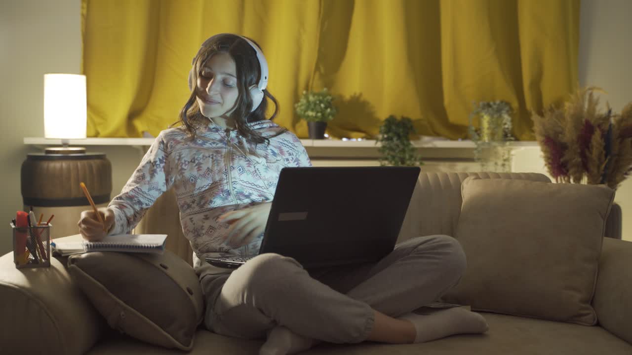 estudiante exitoso mira a la cámara con una sonrisa mientras estudia en casa.