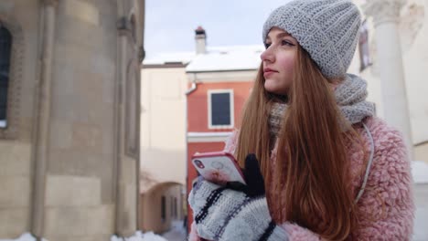 young woman looking at her phone on a cold winter day