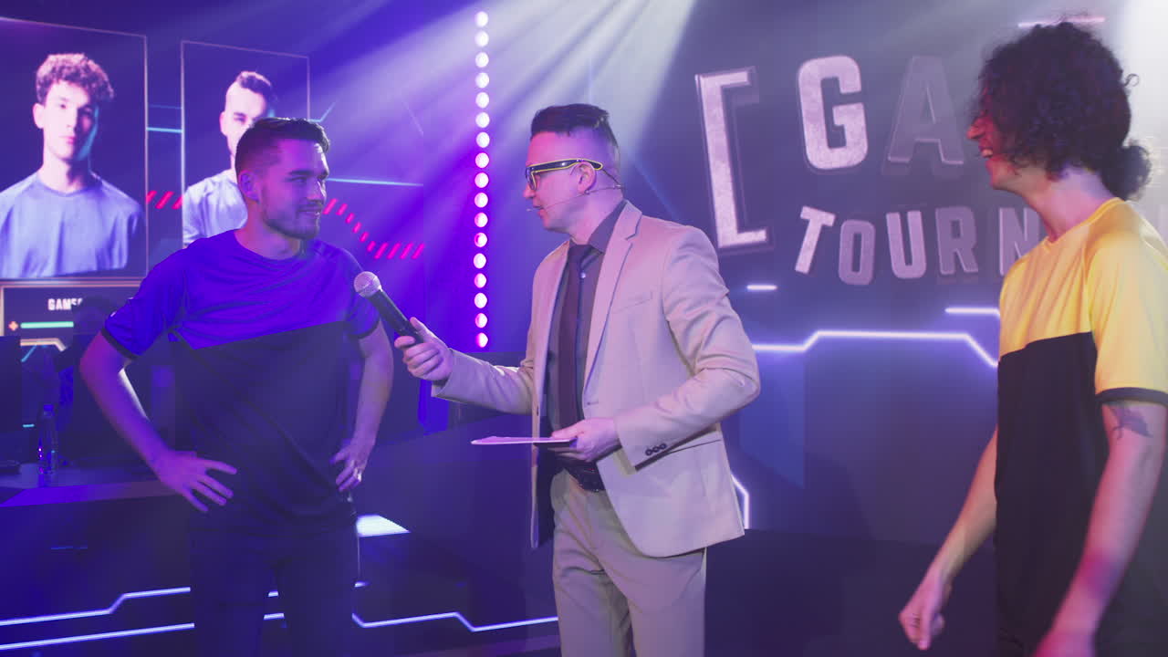 male Announcer Interviewing Team Leaders during Esports Competition Adult Man Host with Microphone Asking Questions to Young Esportsman Male Gamers at Start of Professional Gaming Tournament