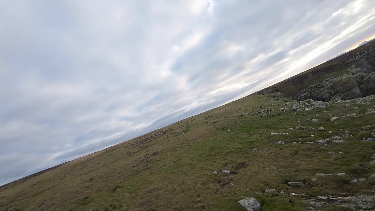 Formazione rocciosa drammatica ripresa dall'alto con volo aereo FPV, costa gallese con paesaggio di promontori a picco