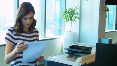 Female-executive-using-photocopier-machine-in-office