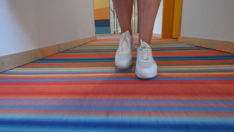 close up of walking feet on striped carpet