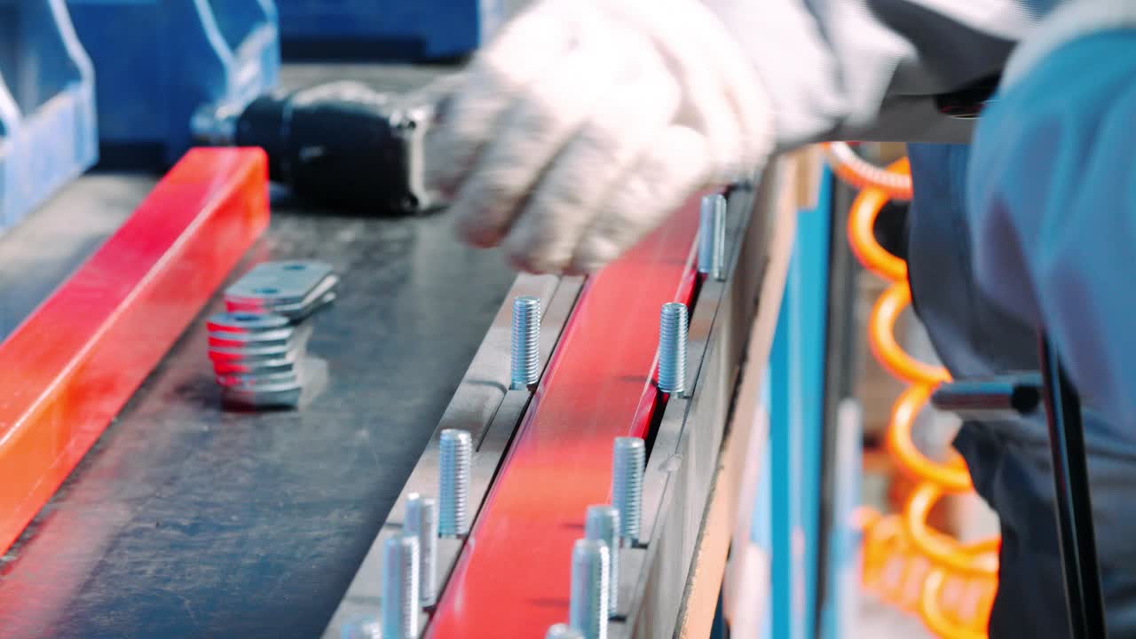 Worker making manual assembly of metal components on industrial unit