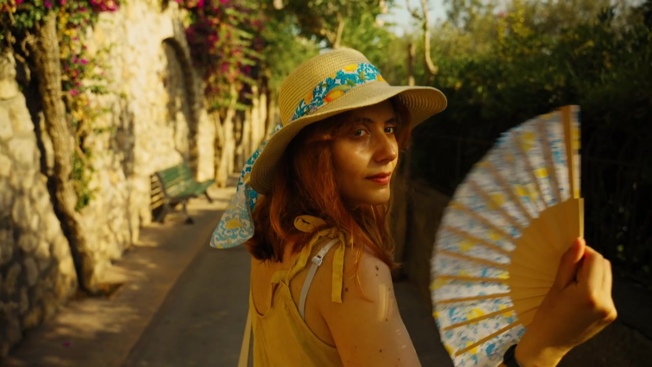 Una turista cammina lungo una strada sull'isola di Capri vicino a hotel di lusso