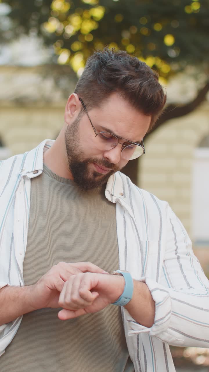 hombre buscando a alguien esperando una reunión enojado frustrado mirada tiempo tocando reloj de muñeca en la calle