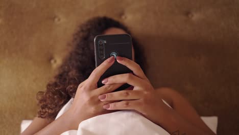 person relaxing in bed using a smartphone