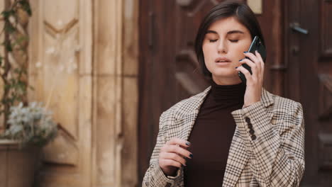 una mujer de negocios caucásica usando un teléfono inteligente al aire libre.