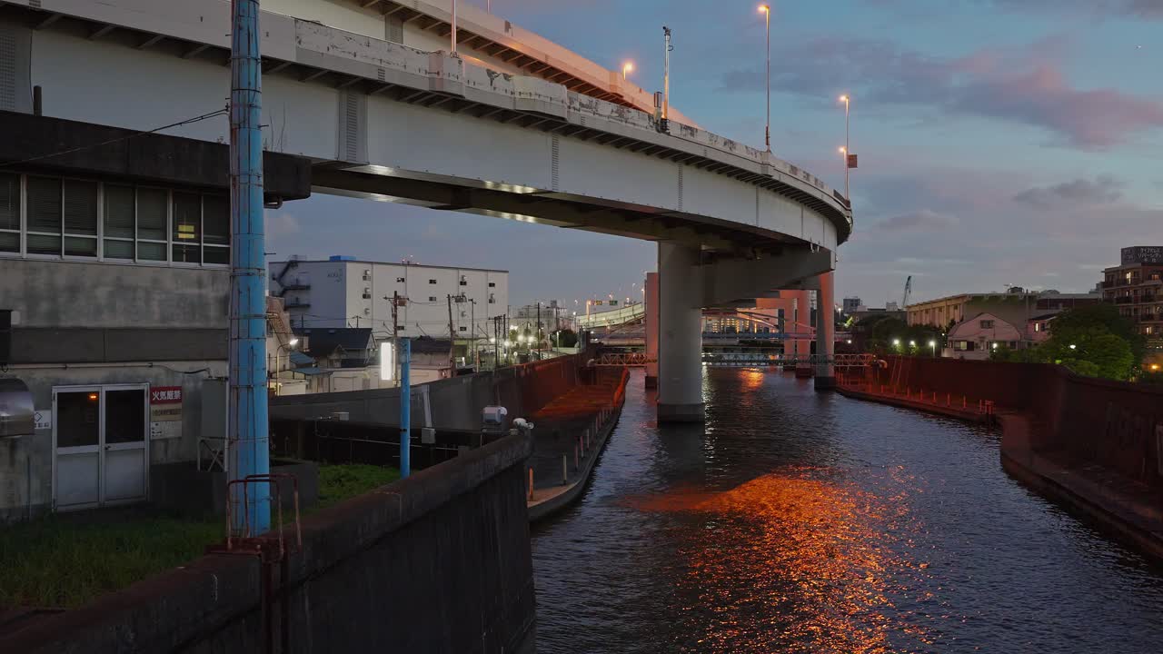 A shot capturing the Ooyokogawa River flowing under the Shuto Expressway and the surrounding urban infrastructure