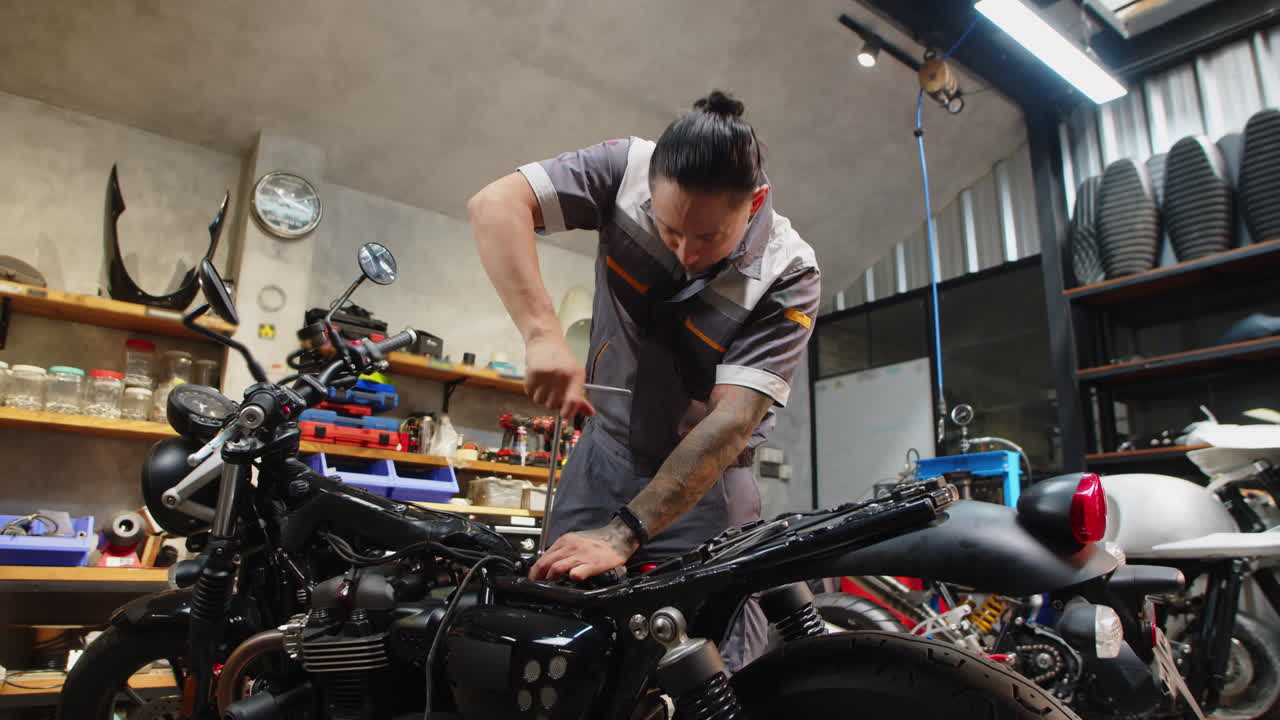 Multiethnic Specialist Using Tool to Repair Broken Motorcycle
