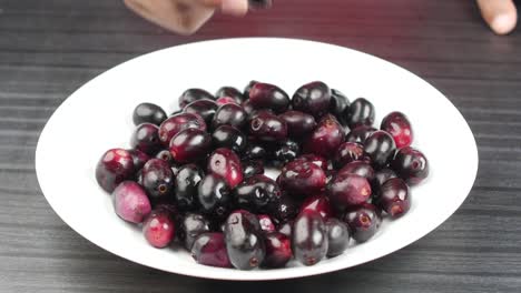 top view of black plum on a plate