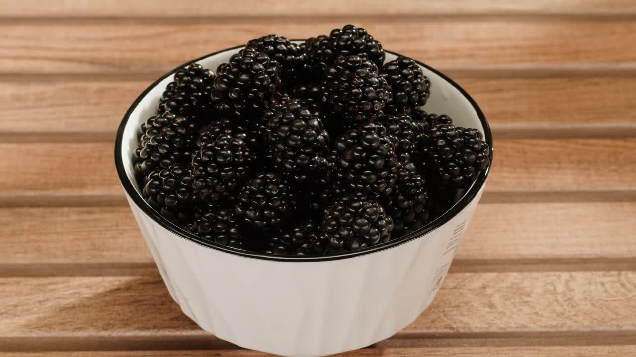 moras en un cuenco blanco en una mesa de madera