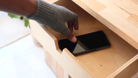 vista de primer plano de un cajón de madera abierto con un teléfono dentro