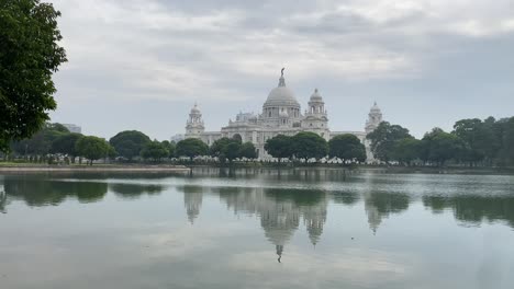 cinematic shot the victoria memorial house, in the memory of queen victoria. the beautiful marble building's reflection falling on the lake built by britishers in kolkata