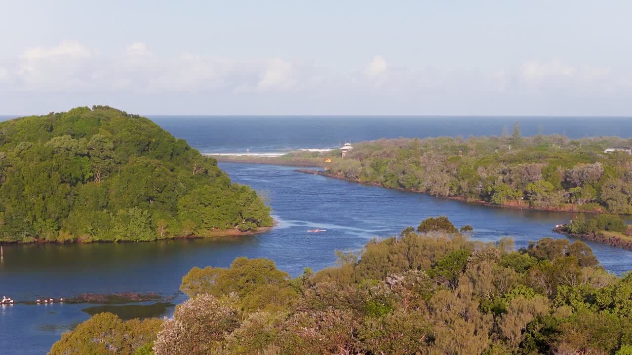 Aerial footage captures a serene river winding through lush islands under clear skies, highlighting natural beauty and tranquility