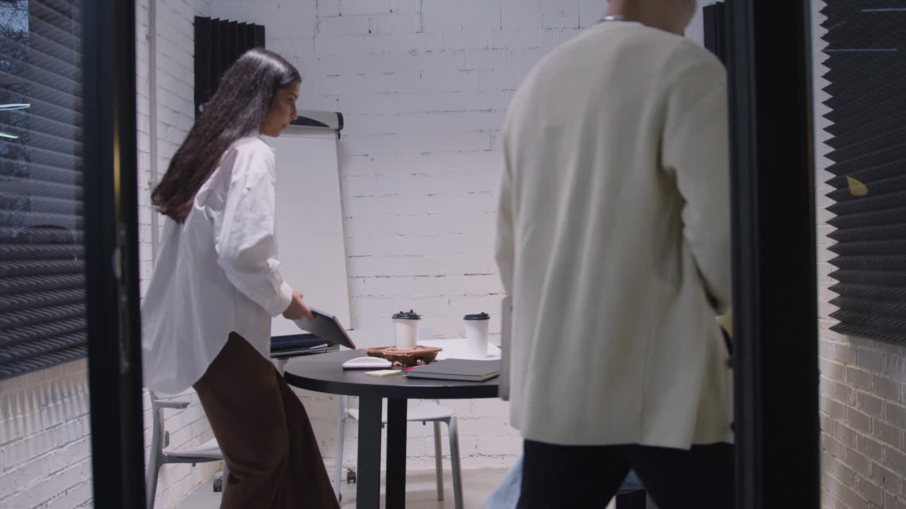 группа разнообразных коллег, проводящих деловую встречу в зале заседаний.