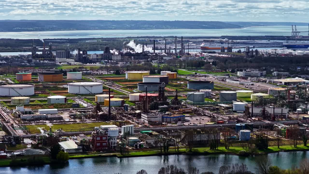 Drone shot of sprawling petrochemical plant near a river estuary and shipping port - Havre, France
