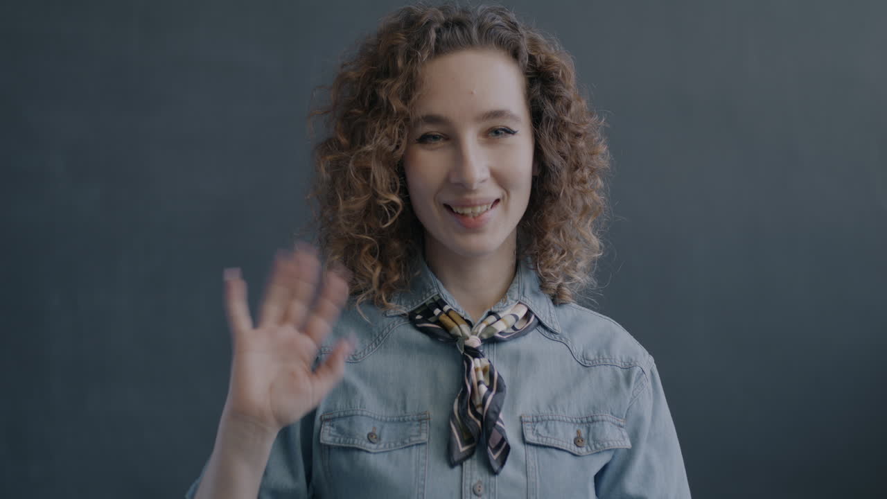 una mujer saludando.