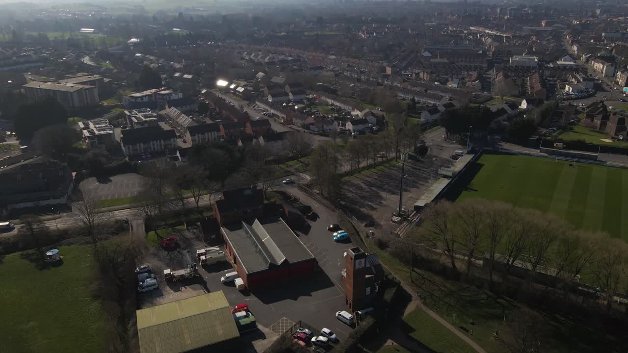 영국 톤턴 서머셋에 있는 소방서의 4k 공중 전망, 드론이 앞으로 이동하고 일부 구름과 함께 푸른 하늘을 드러내