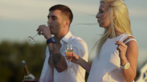 una pareja bebiendo champán en un barco.