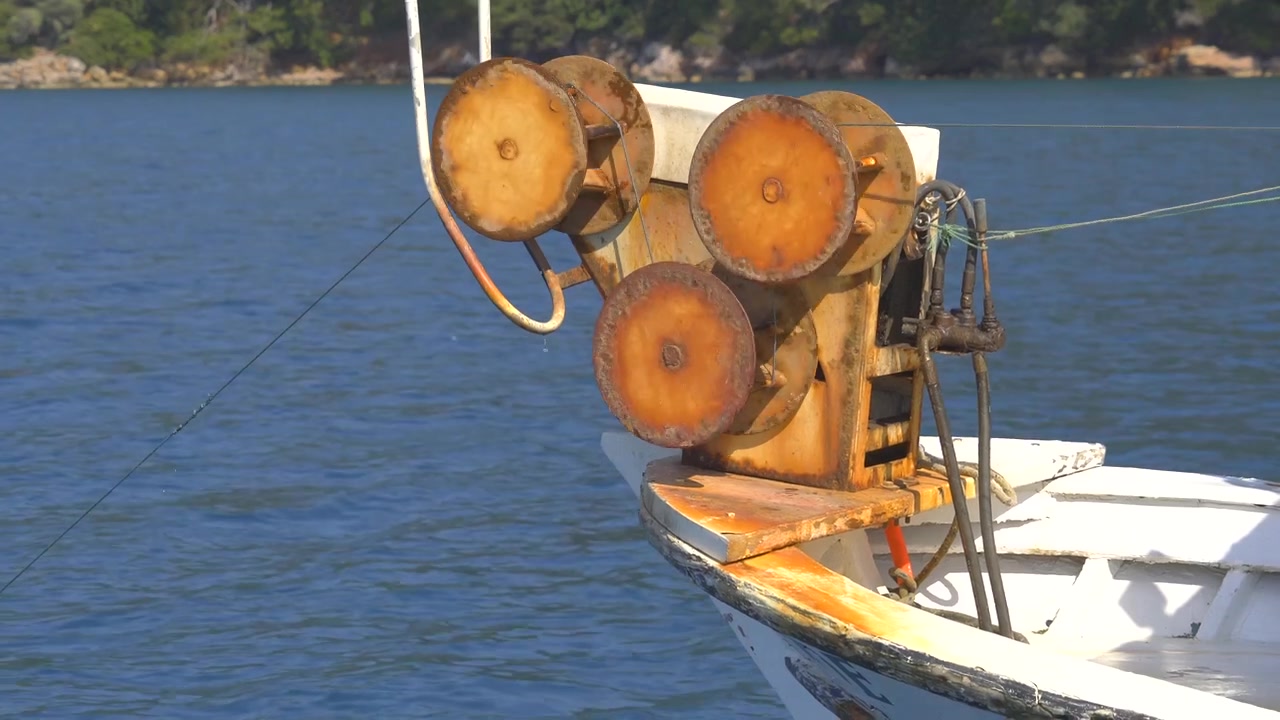 Primo piano di un argano arrugginito per reti da pesca sulla prua di una barca