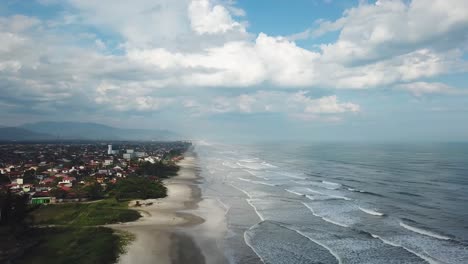 Ascending-establishing-shot-of-Itanhaem-beach-in-summer-time-in-Brazil,-beautiful-sky-and-ocean