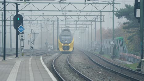 Tren-Moderno-Amarillo-Que-Para-En-La-Estación-Para-Recoger-Gente,-Holanda,-Rotterdam