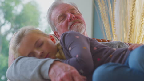 grandmother taking picture of grandfather and granddaughter having daytime sleep at home together