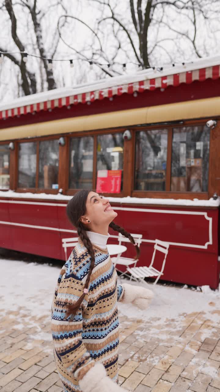 mujer disfrutando de un día nevado fuera de un café