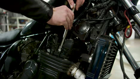 unrecognizable man fixing motorcycle