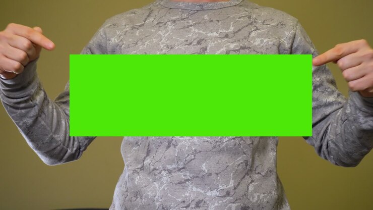 Uomo che allarga le mani ai lati e mostra un banner chroma key su schermo verde.