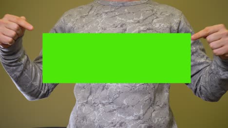 man spreads hands to sides and show green screen chromakey banner