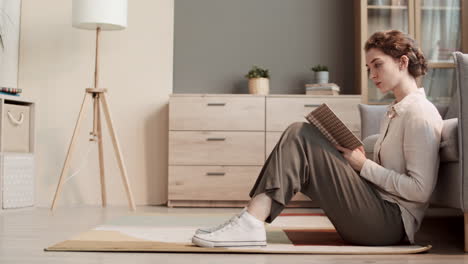 mujer leyendo un libro sentada en el suelo