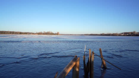 pan shot of a frozen lake in winter by sunset