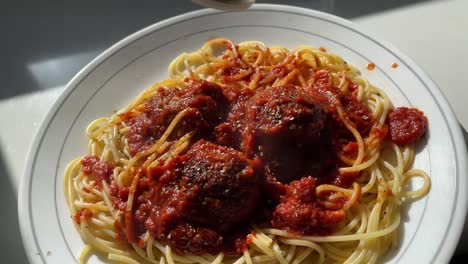 fideos espaguetis y albóndigas en un plato blanco