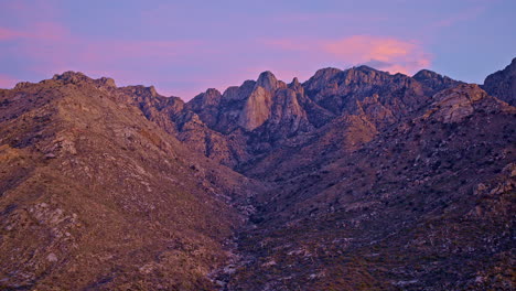 drone shot at sunset revealing mountain valley with desert flora in tucson arizona