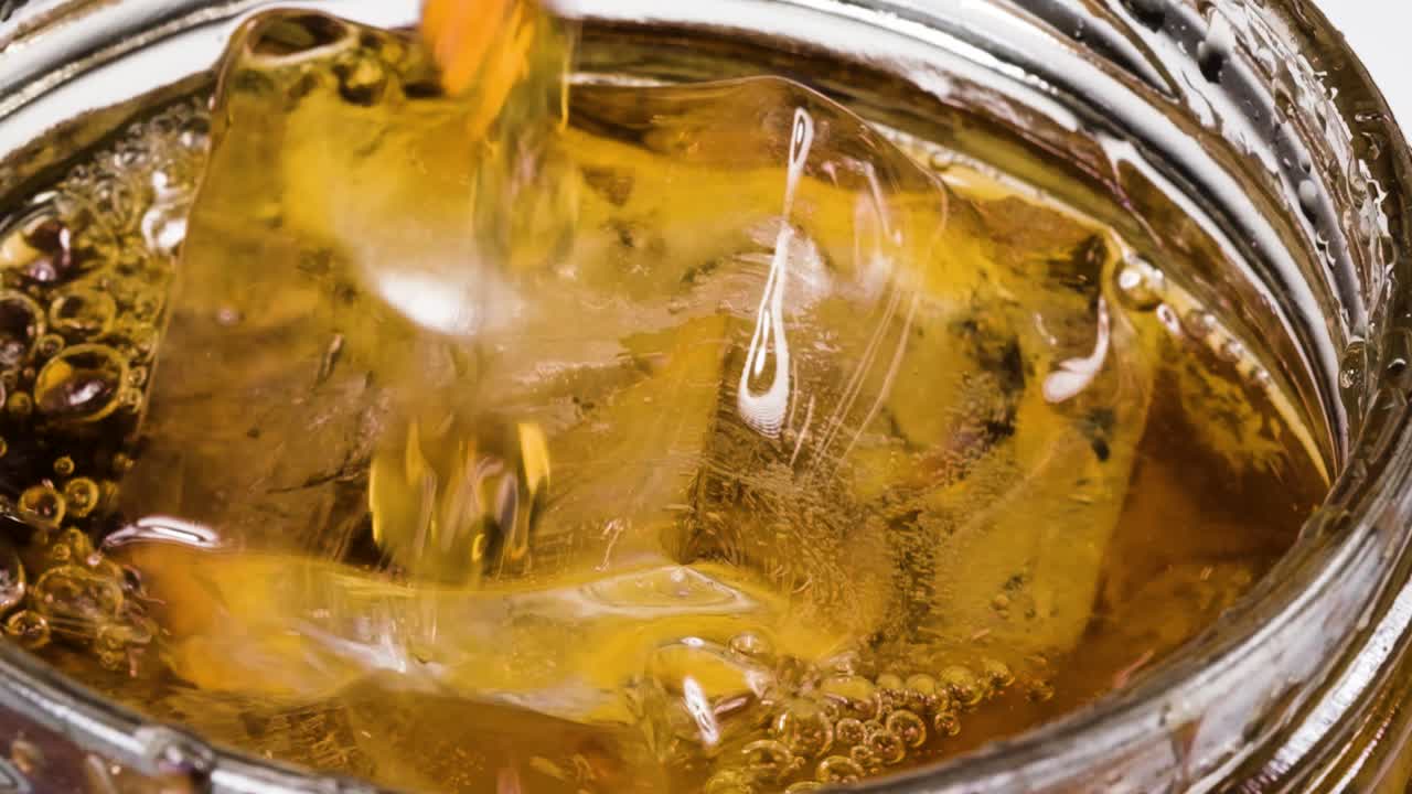 Macro shot Pouring Vermouth on top of ice cube into glass, Fortified wine, Slow motion shot