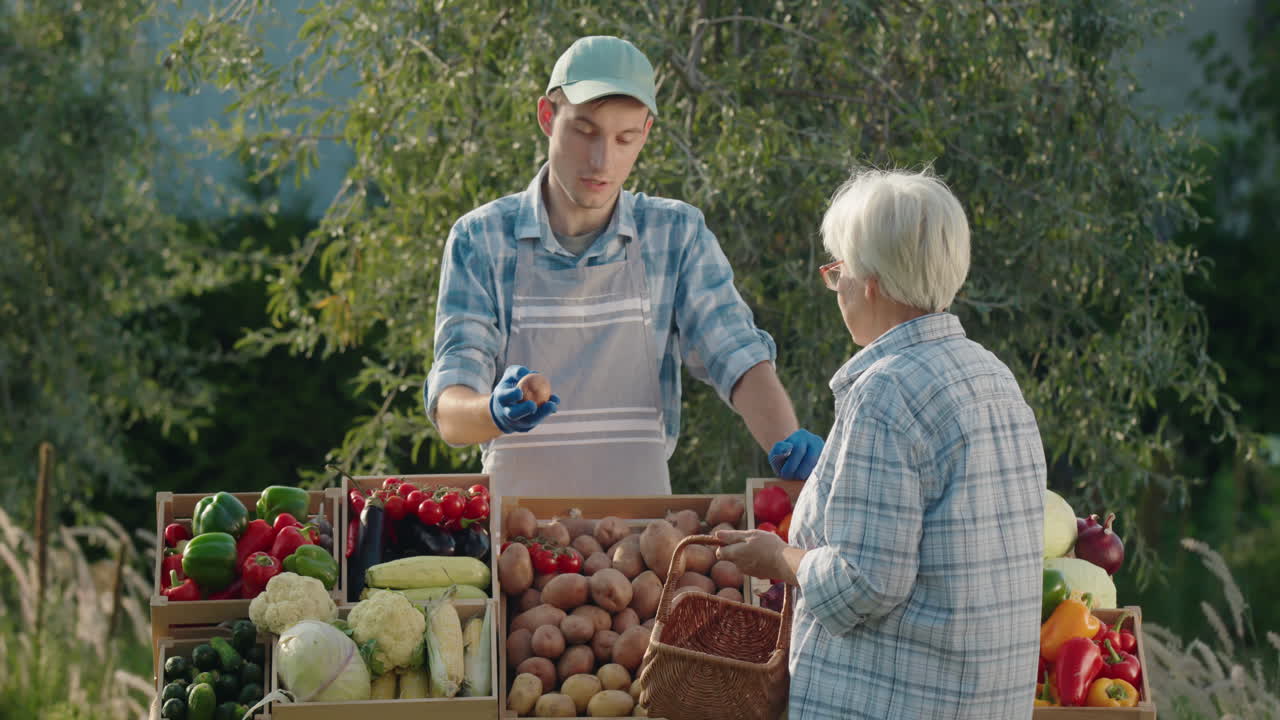 Elderly lady with a basket in her hand buys vegetables at the farmers market