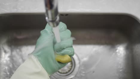 washing a sponge under a faucet