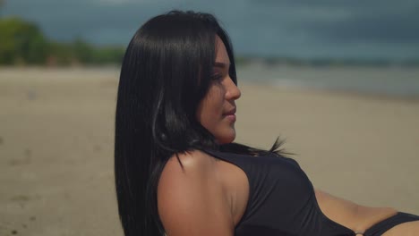 at vessigny beach on the south coast of the tropical island of trinidad, a latina girl embraces the sun in a bikini laying in the sand