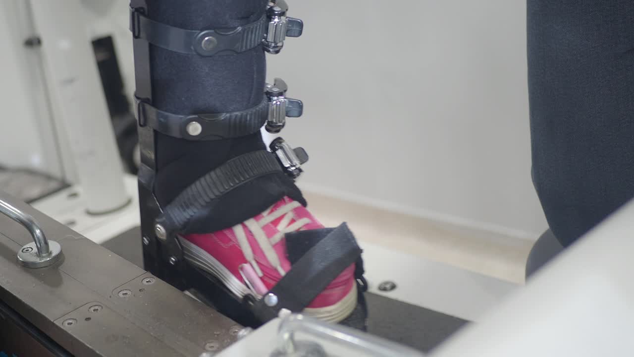 Person's leg in a rehabilitation brace on a therapy machine